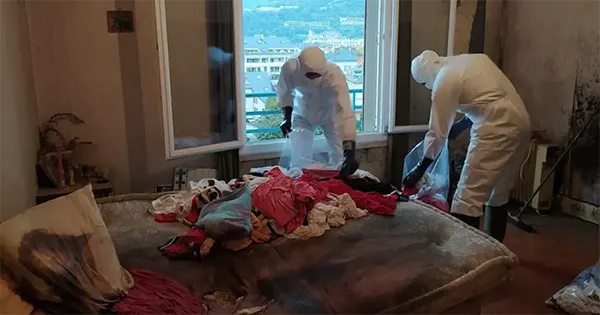 Équipe spécialisée en nettoyage après décès, équipée de protections et de matériel professionnel