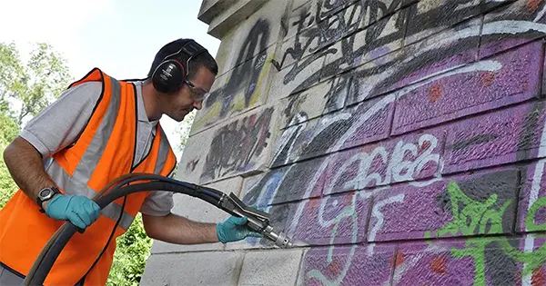 Technicien en train d'éliminer des graffiti sur un mur sans solvants agressifs