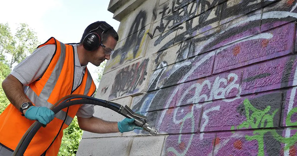 Technicien en train d'éliminer des graffiti sur un mur sans solvants agressifs